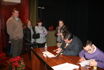 José María Díaz firmando ejemplares de su libro acompañado por su hijo mayor