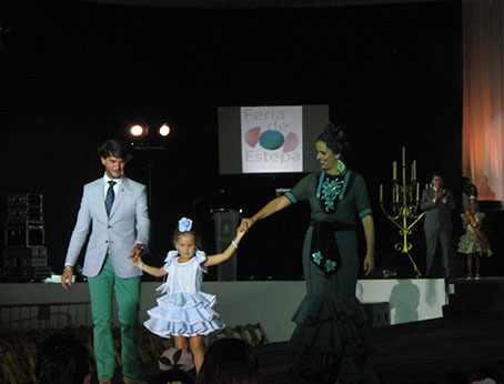 Beatriz García y Francisco Javier Rodríguez, presentadores del evento, con la niña ganadora